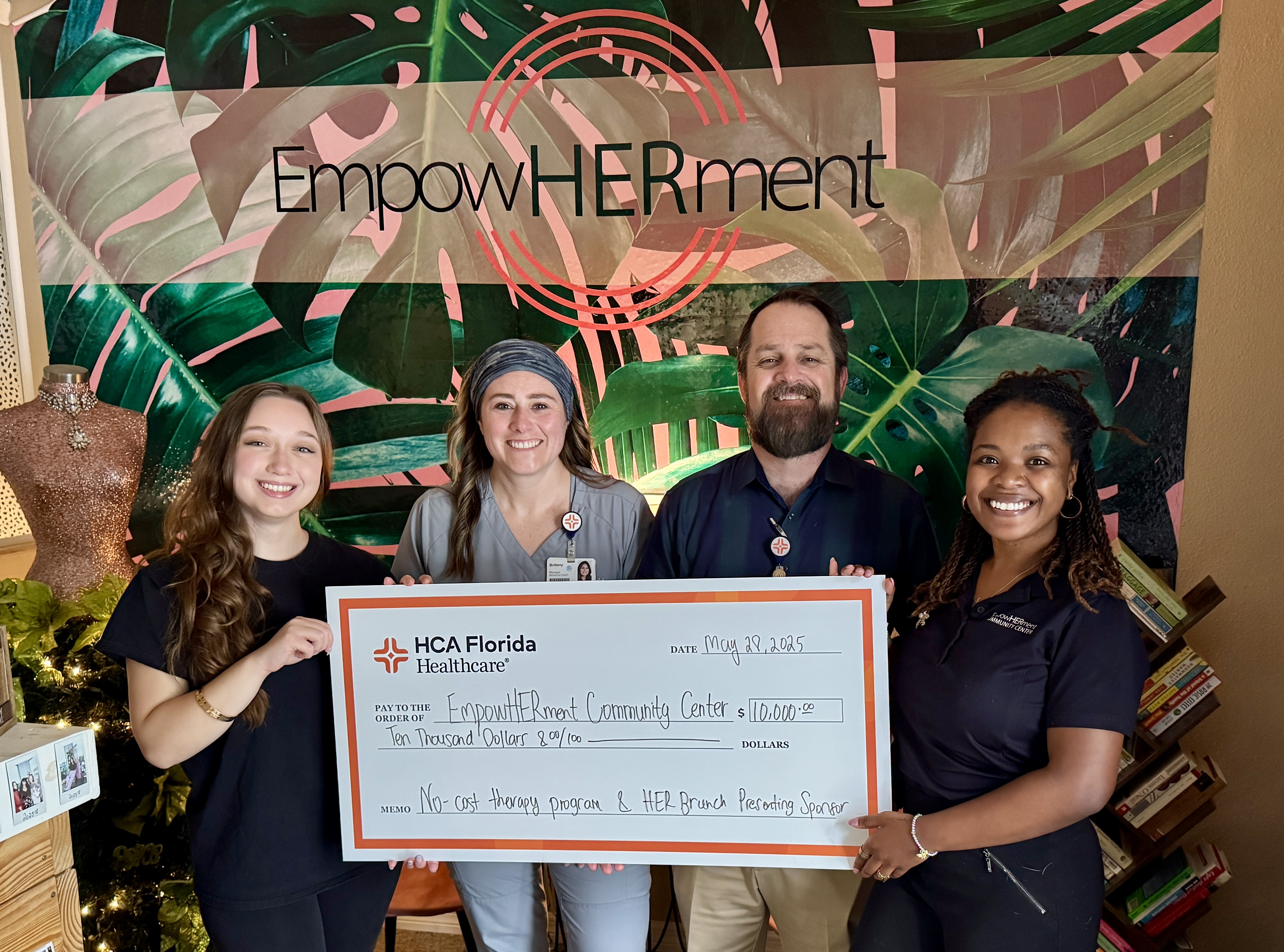 group of healthcare professionals and community partner holding large sponsorship check