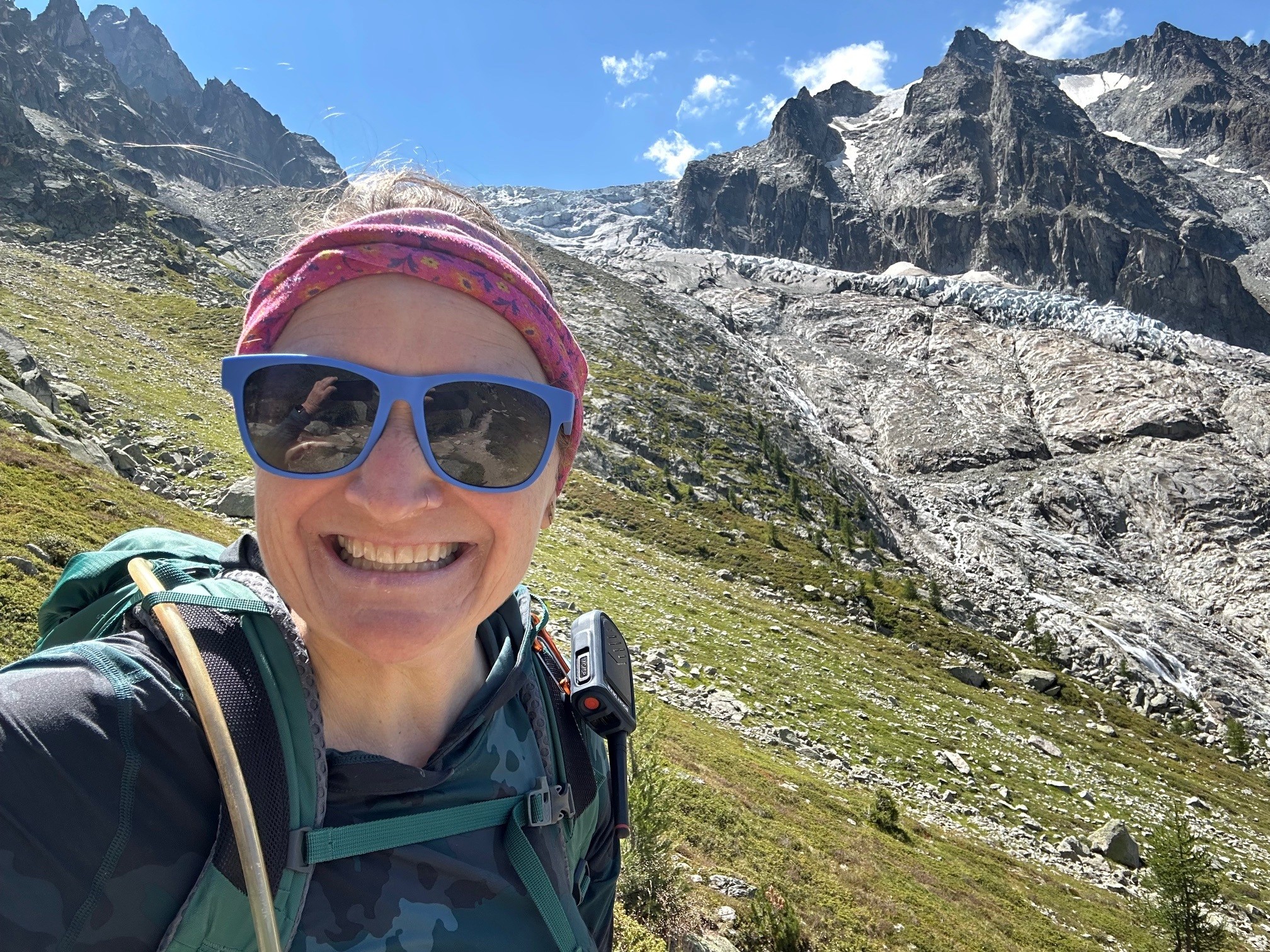 Anne Herbst taking a photo outside by a mountain.