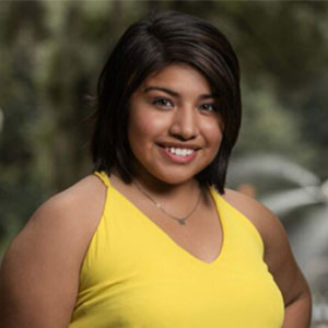 Mariela Villa smiling in a yellow dress.