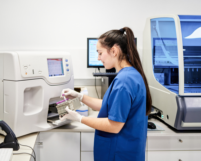 A medical professional in scrubs organizing test tubes.