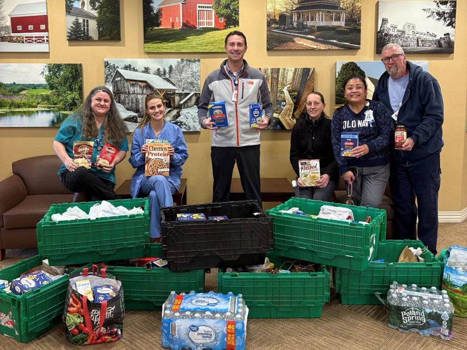 Colleagues from Portsmouth Regional Hospital gathered around donated food items.