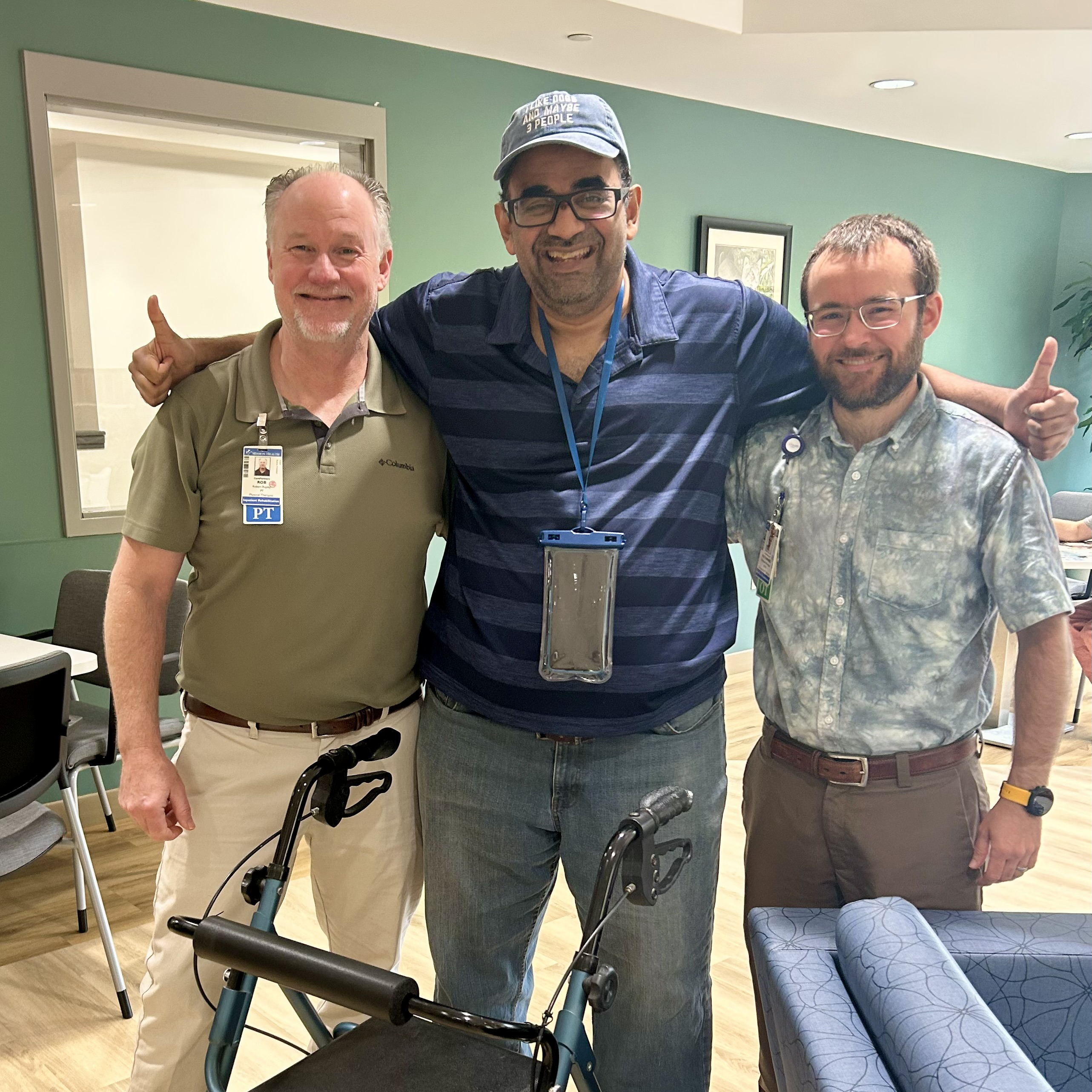 David Leonard stands smiling with two of his care providers.