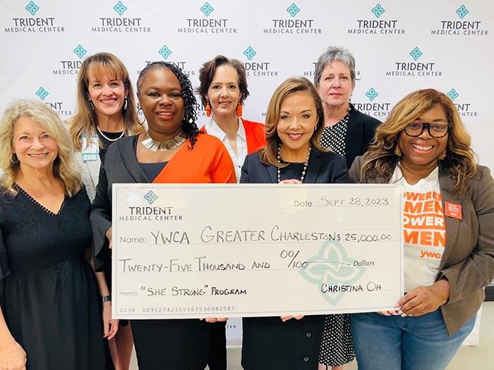 Staffers from YWCA of Charleston and Trident Medical Center hold giant charitable check in the amount of $25,000 for the "She Strong" program.