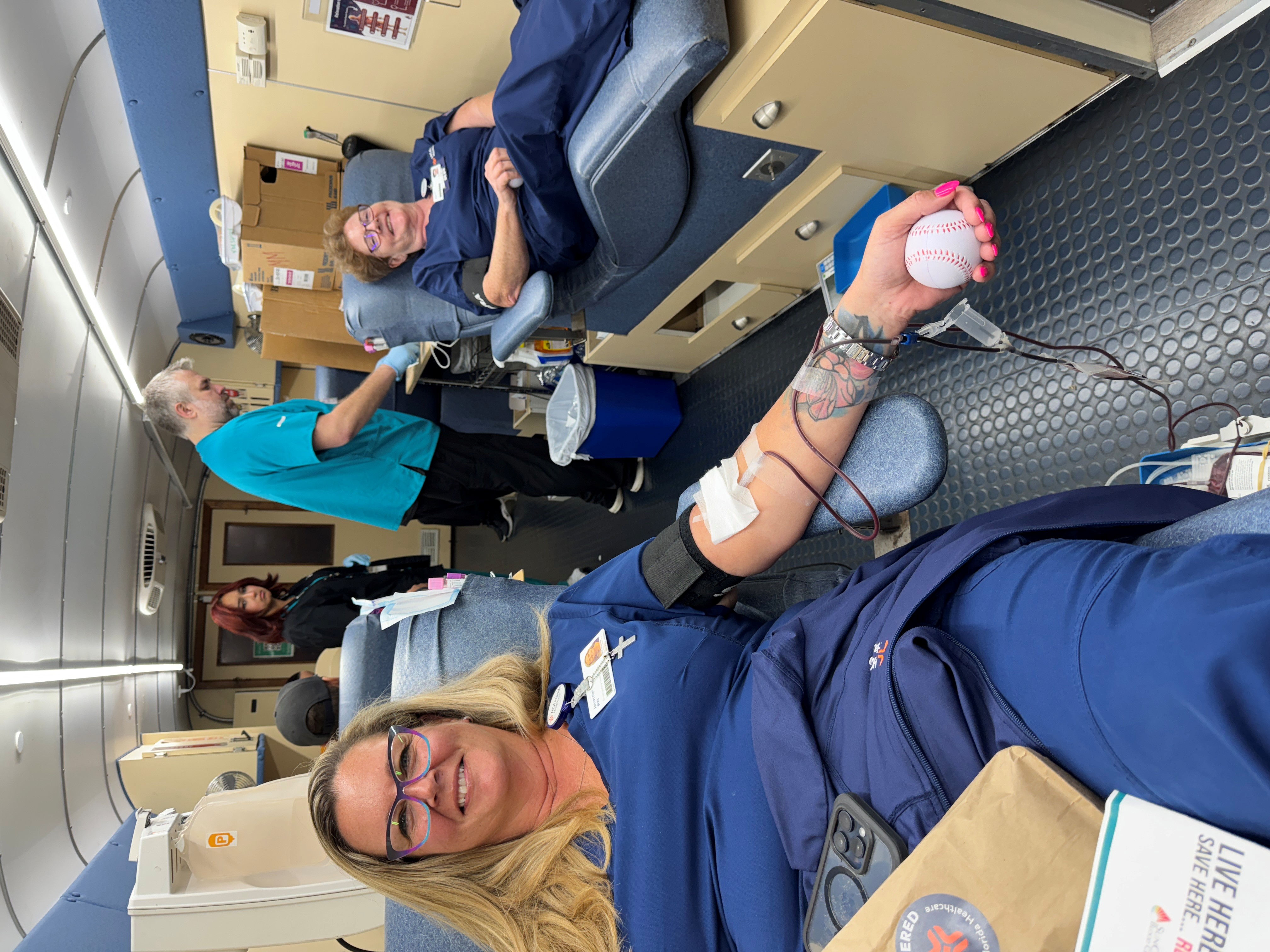 Two nurses lay on beds donating blood