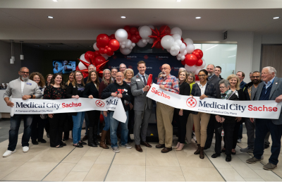 Large group of hospital staff cutting ribbon to celebrate One Year Anniversery.