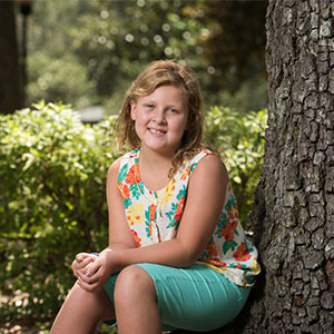 Ilian Schraeder sitting next to a tree.