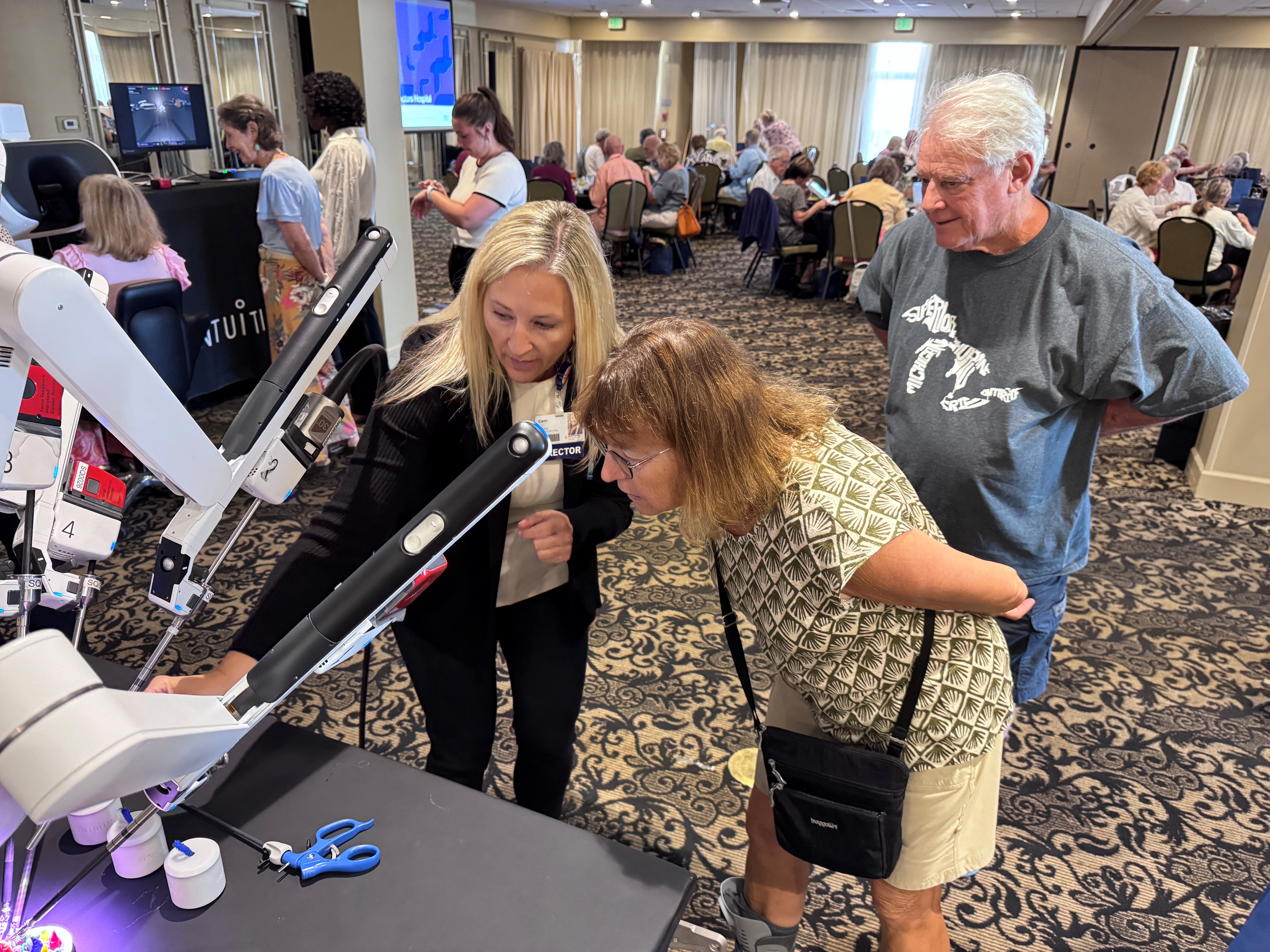 A nurse from Sarasota Doctors Hospital points out a feature on a surgical robot during an open house for patients