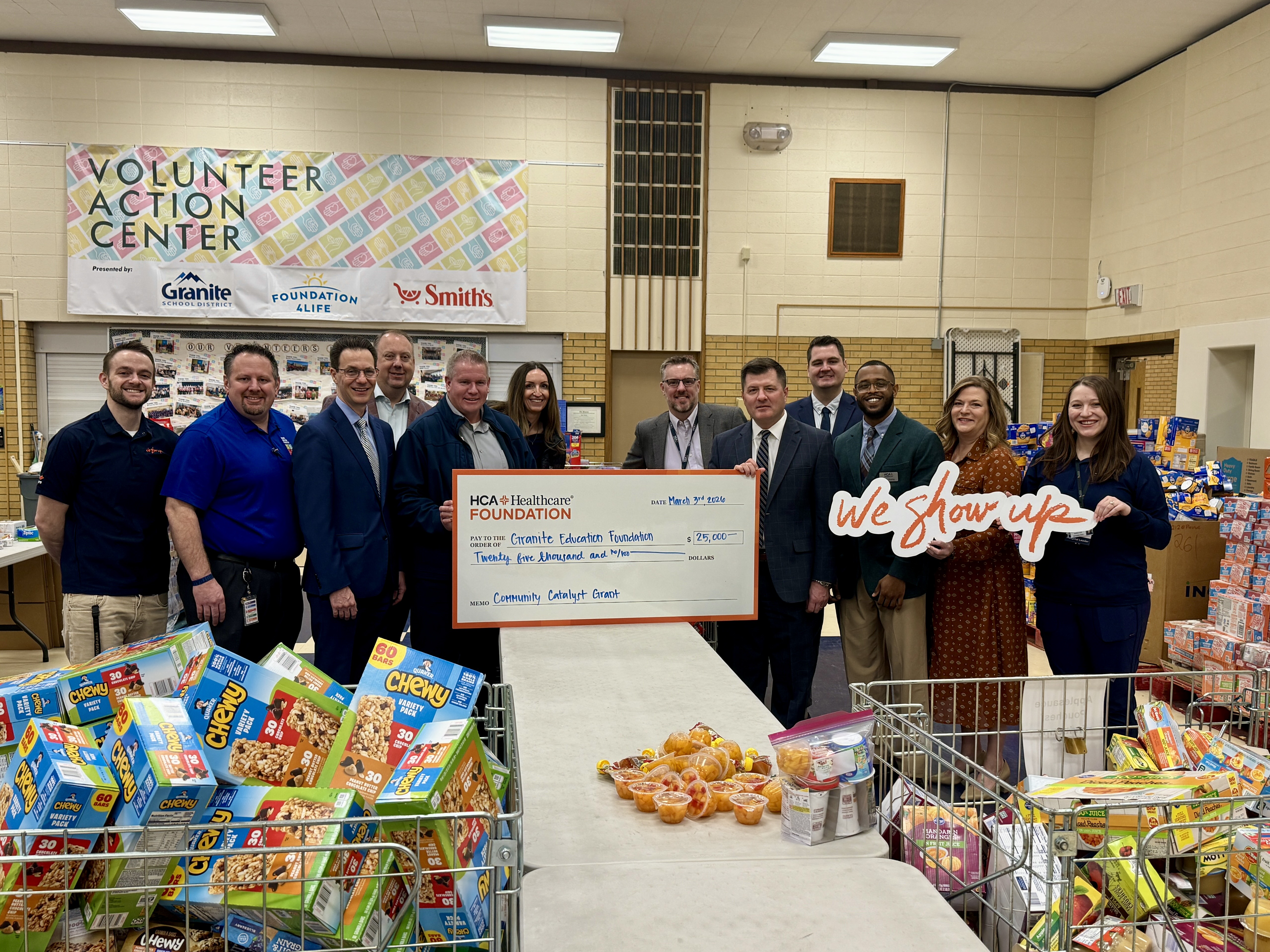 Members of the administration team at St. Mark's Hospital, executive team at HCA Healthcare's Mountain Division – MountainStar Healthcare – and the Granite Education Foundation pose together in a group, smiling, at the school foundation. 