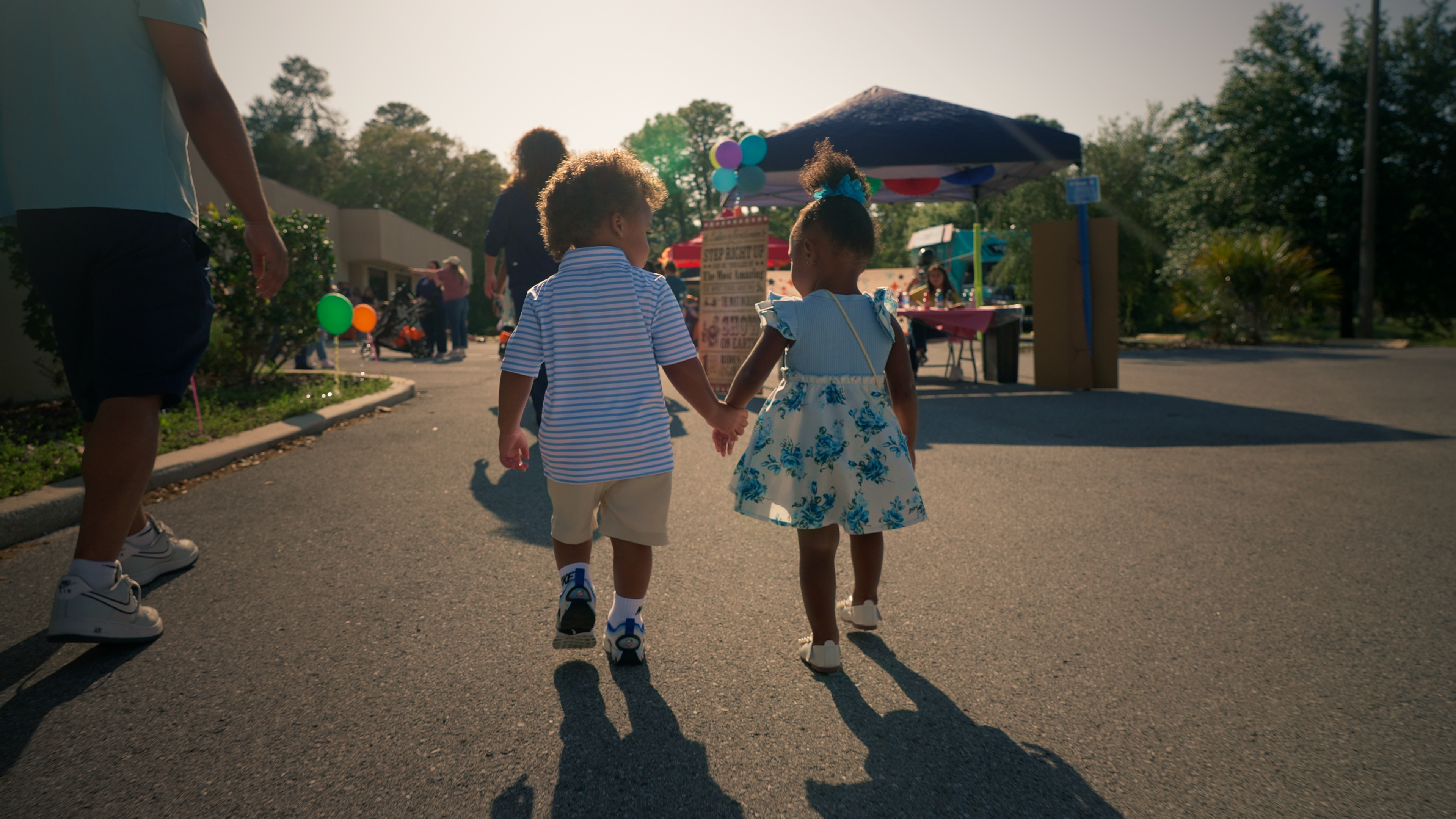 Two toddlers walking and holding hands