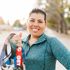 Elena wearing a turquoise-colored zip up jacket and smiling.