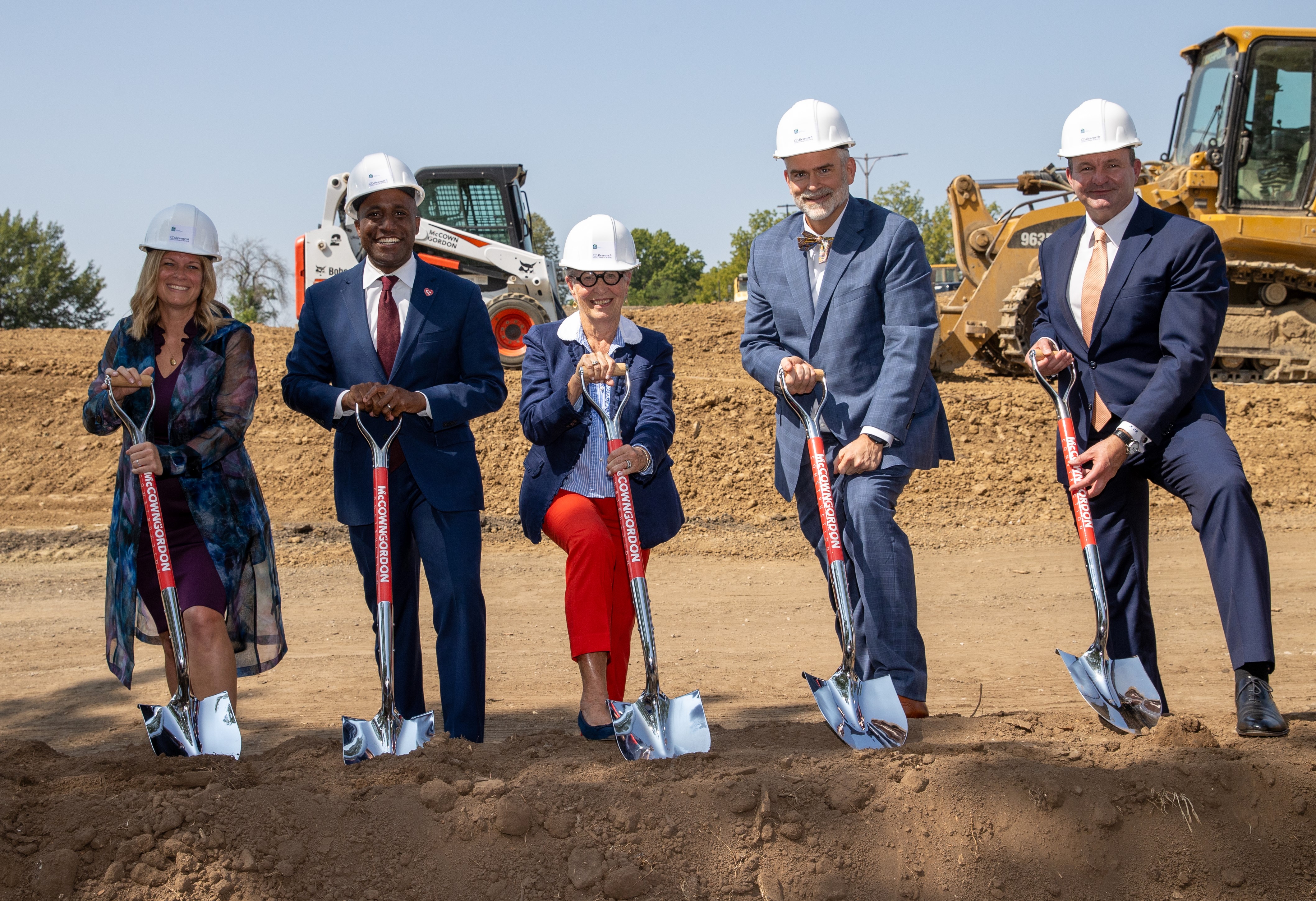 5 people holding shovels for the ground breaking of the new college 