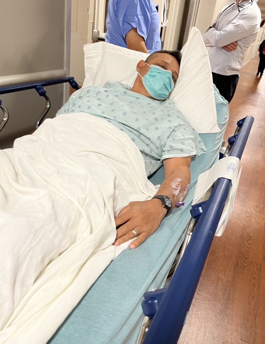 Arthur Guzman pre-surgery being wheeled around in a hospital bed.