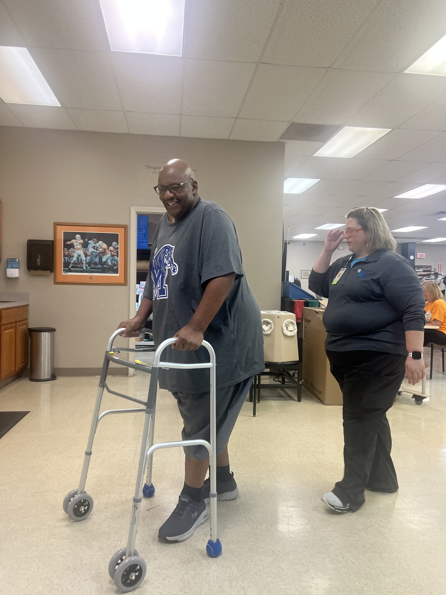 Vestor Jones during rehab in the hospital as he walks with a cane for assistance.