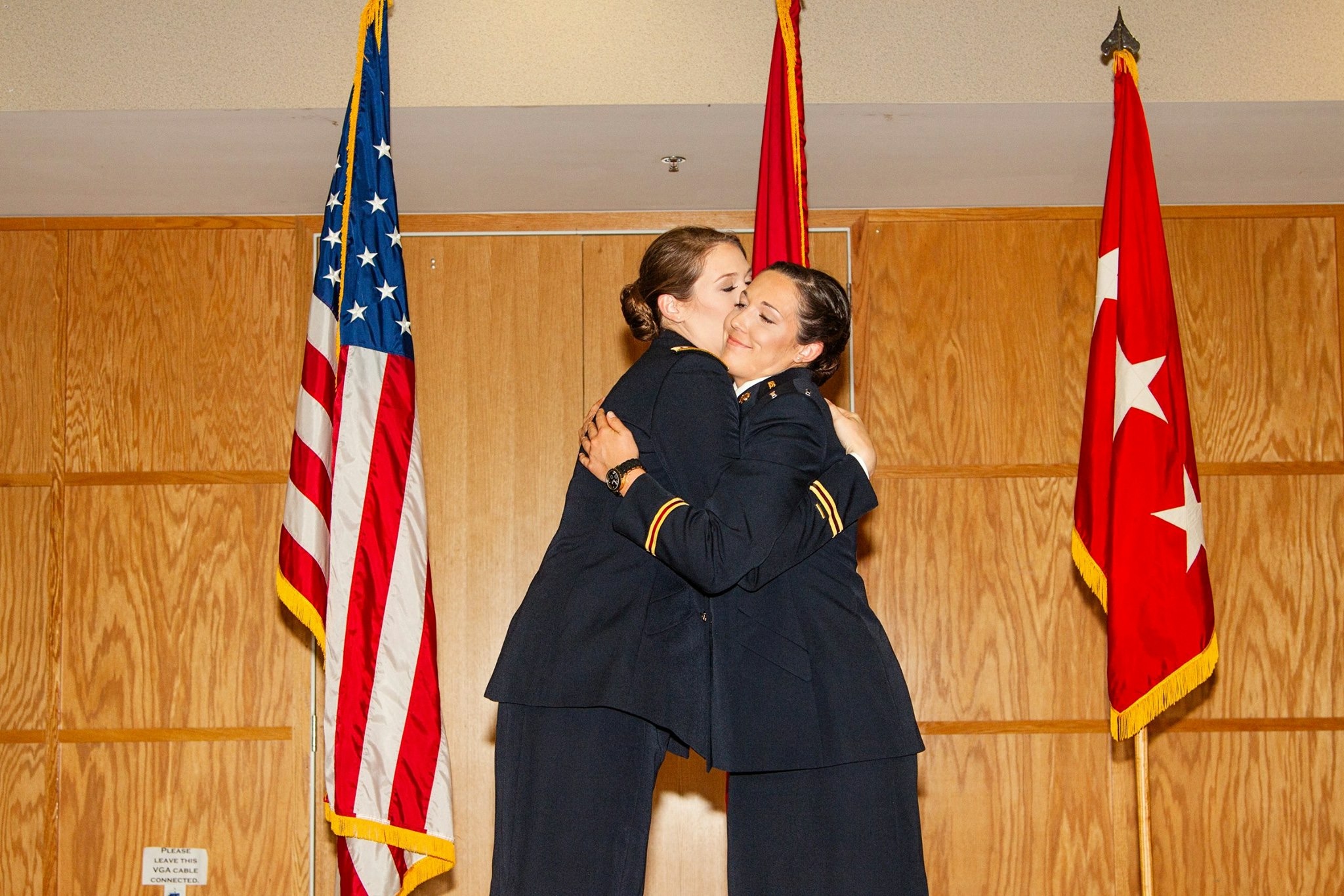 Taylor and Alex hugging each other following a ceremony.
