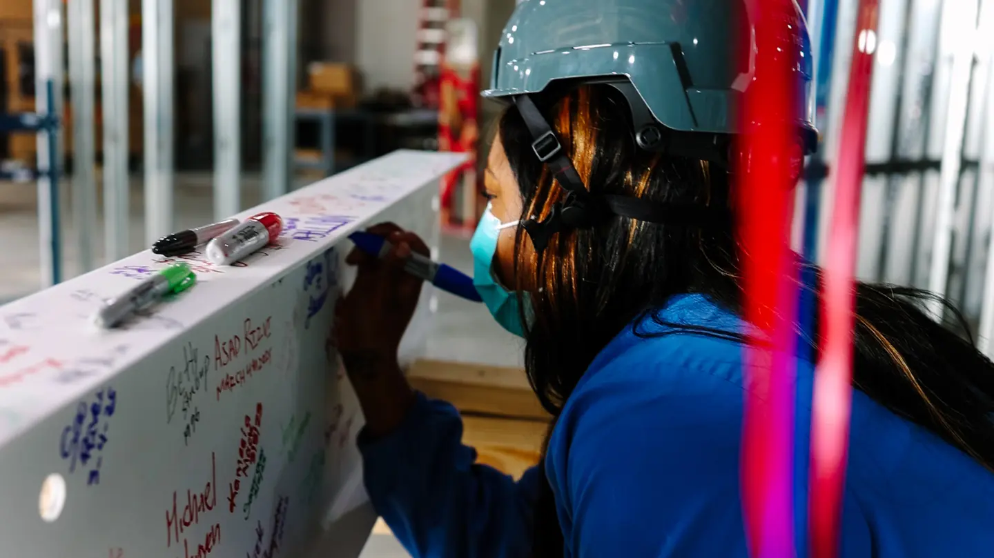 Close up photo of team member signing the beam.