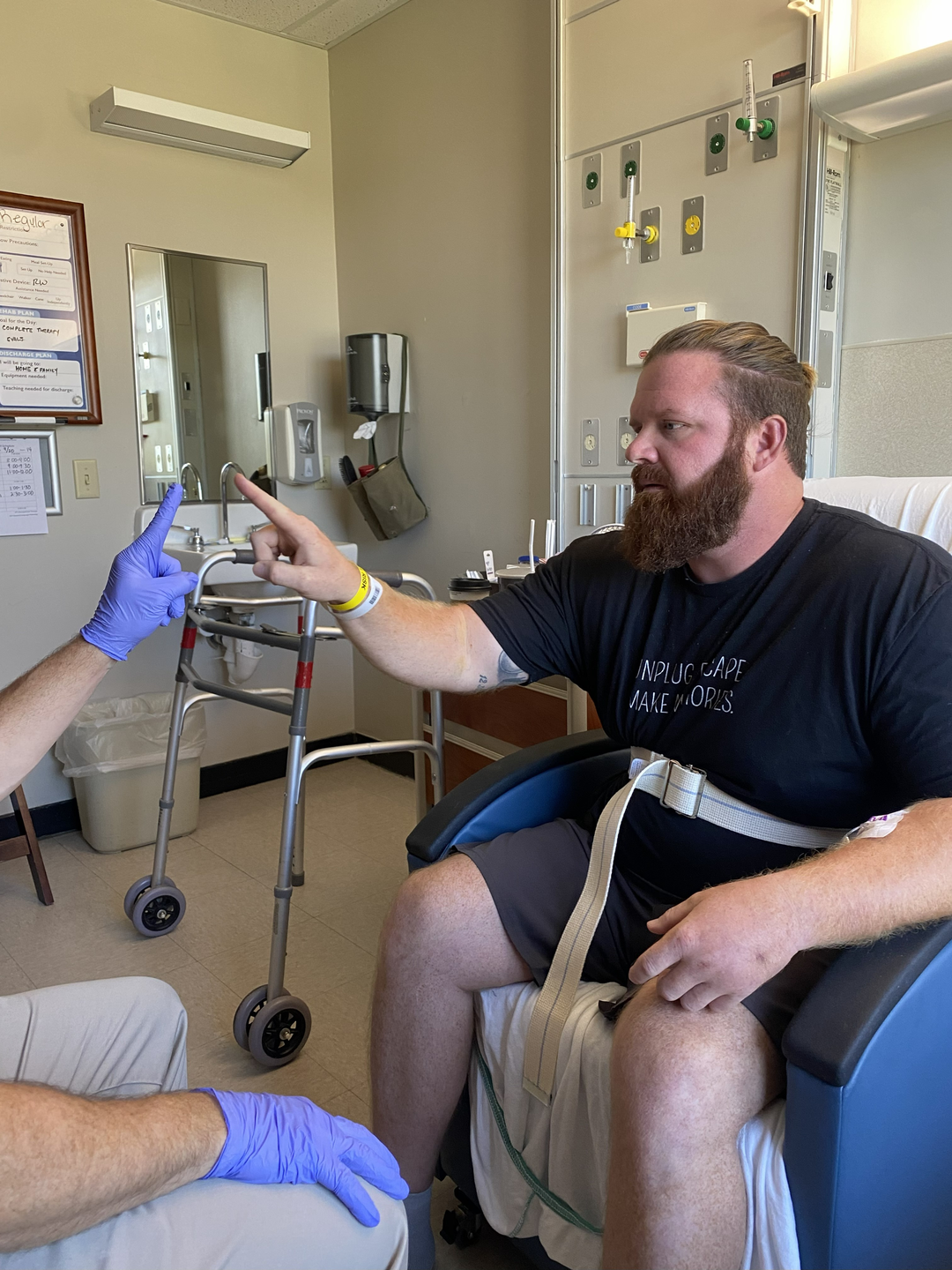 Dean smiling with hospital team in front of sign that reads 'A History of Healing.'