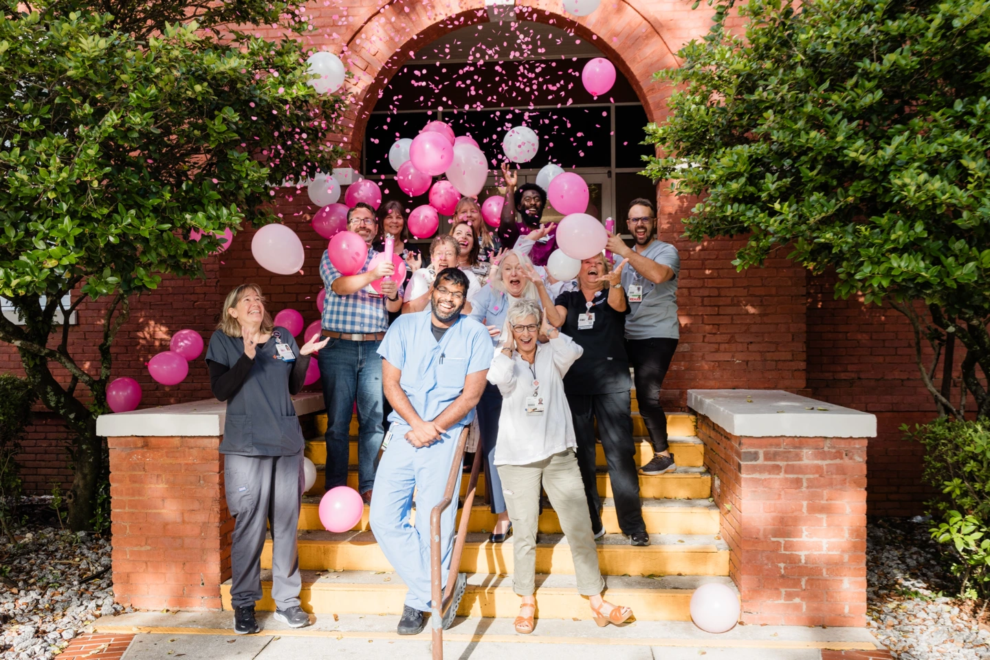 Citrus staff celebrates COC Accredidation with pink confetti and pink balloons.