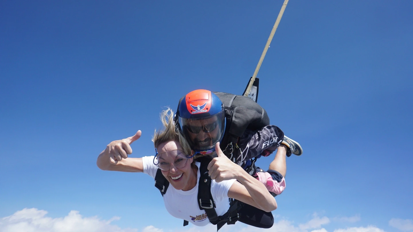 Mary poses for the camera mid-air during her first skydive (tandem with an instructor).