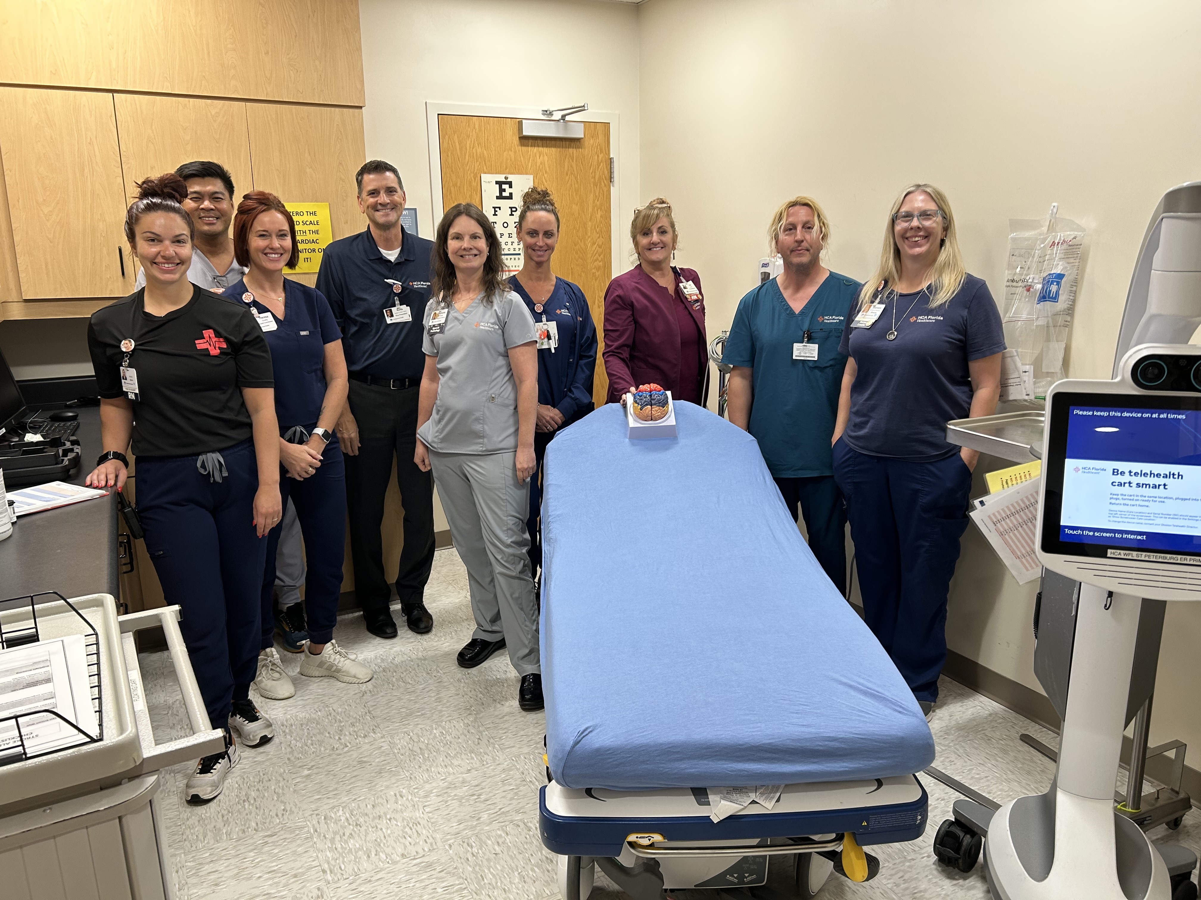 St. Petersburg Hospital's Stroke Care team smiling for a picture in a hospital room,