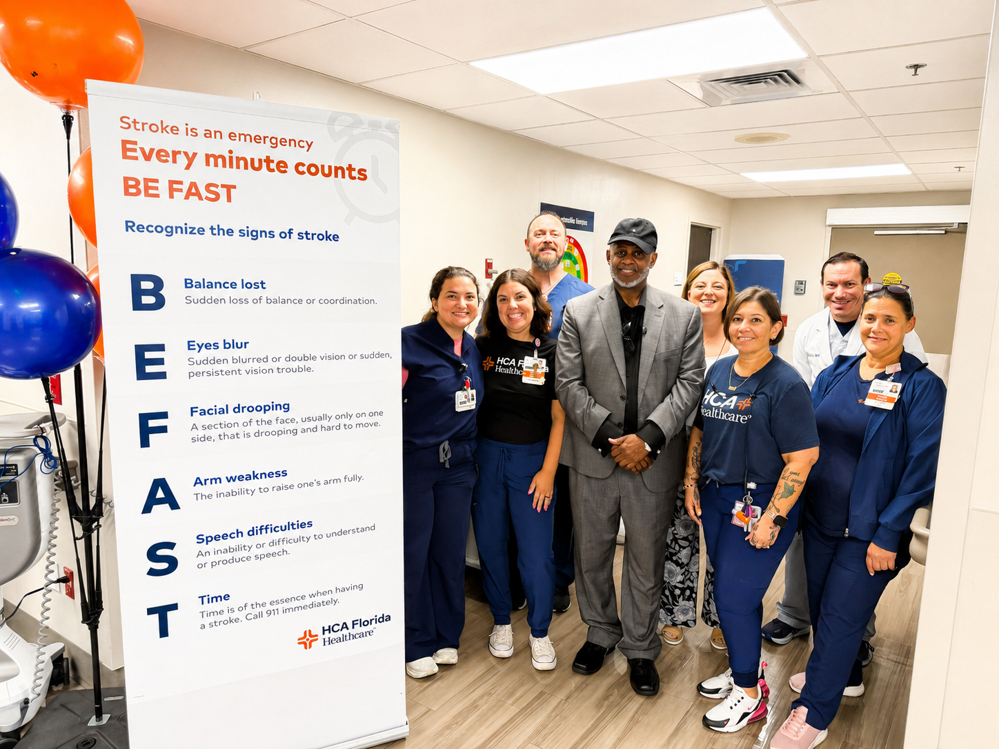 James Feazell and hospital colleagues stand next to B.E.F.A.S.T. banner celebrating his recovery.