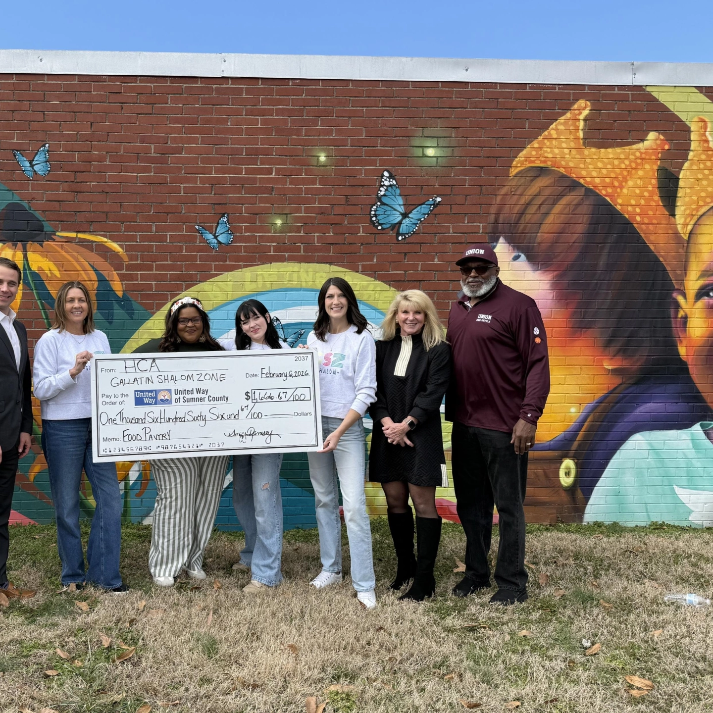HCA team members present donation to Shalom Zone food pantry.