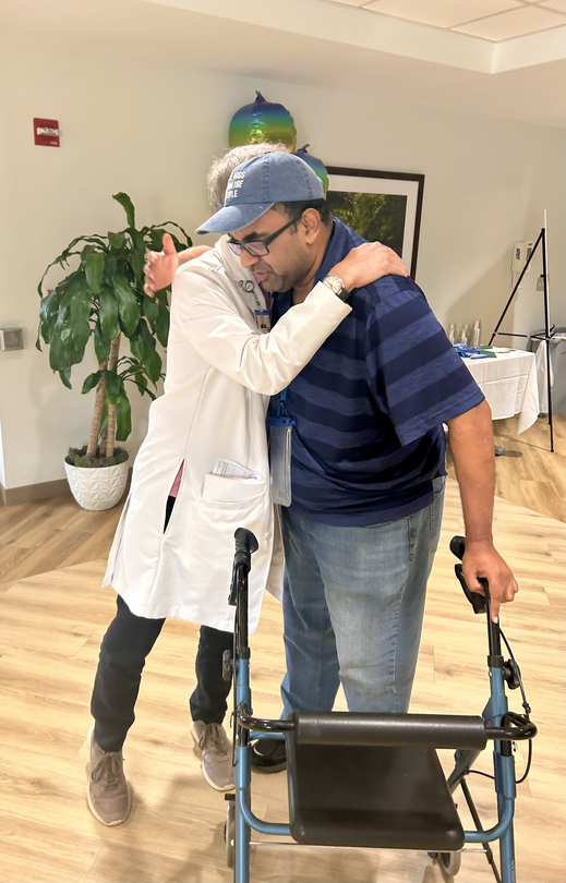 David Leonard embraces his one of his care providers while leaning on a walker.