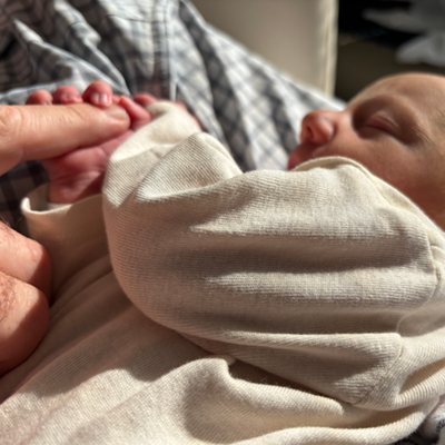 Karleigh and Will's baby grasping Will's finger.