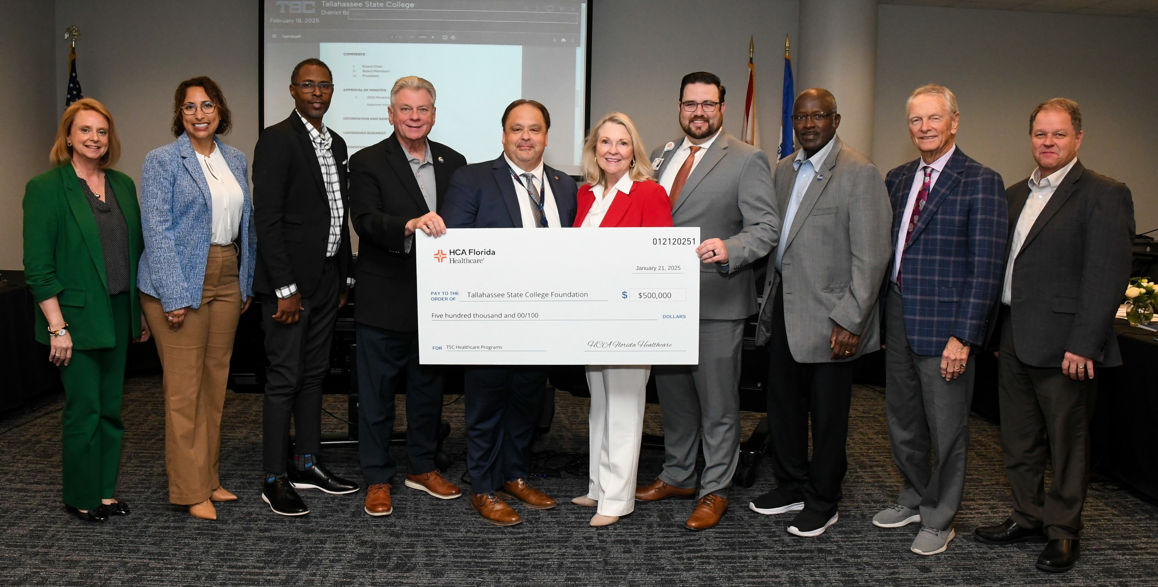 Group of people holding large check
