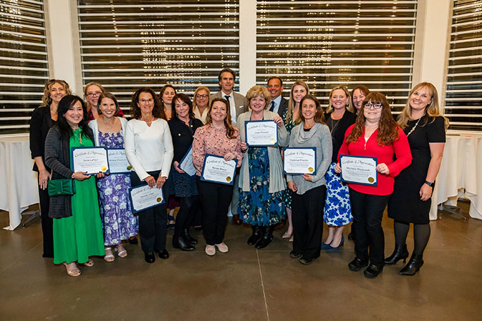 Melody Healy and Cadence Proctor, of Frisbie Memorial Hospital; Krista Chisholm, Kristine Smith, Deena Fullwood, Renee Broyer, Joice LaFleur, Michelle Wojtysiak, Kathleen Hamel, Maureen Rivet, 
Denise Jules, Joan Florent, Wendy Calderwood, and Susan Ray, of Portsmouth Regional Hospital, surrounded by colleagues.