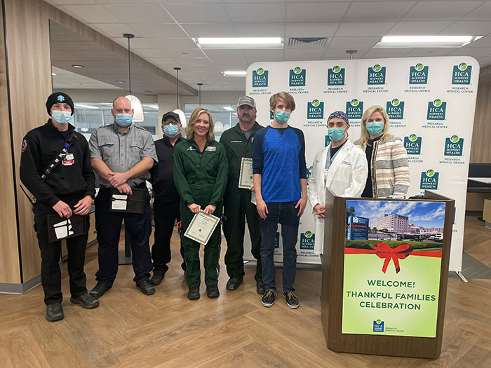 Noah and his care team smile while wearing blue face masks during the Thankful Families Celebration.
