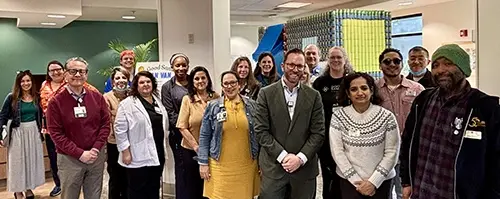 Good Samaritan hospital staff, and representatives from West Valley Community Services and community members stand together in the lobby.