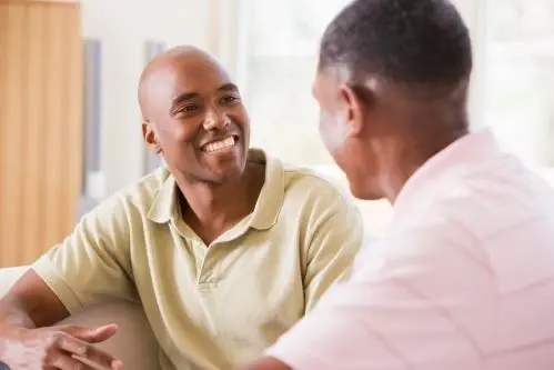 two young men in polos smiling and talking