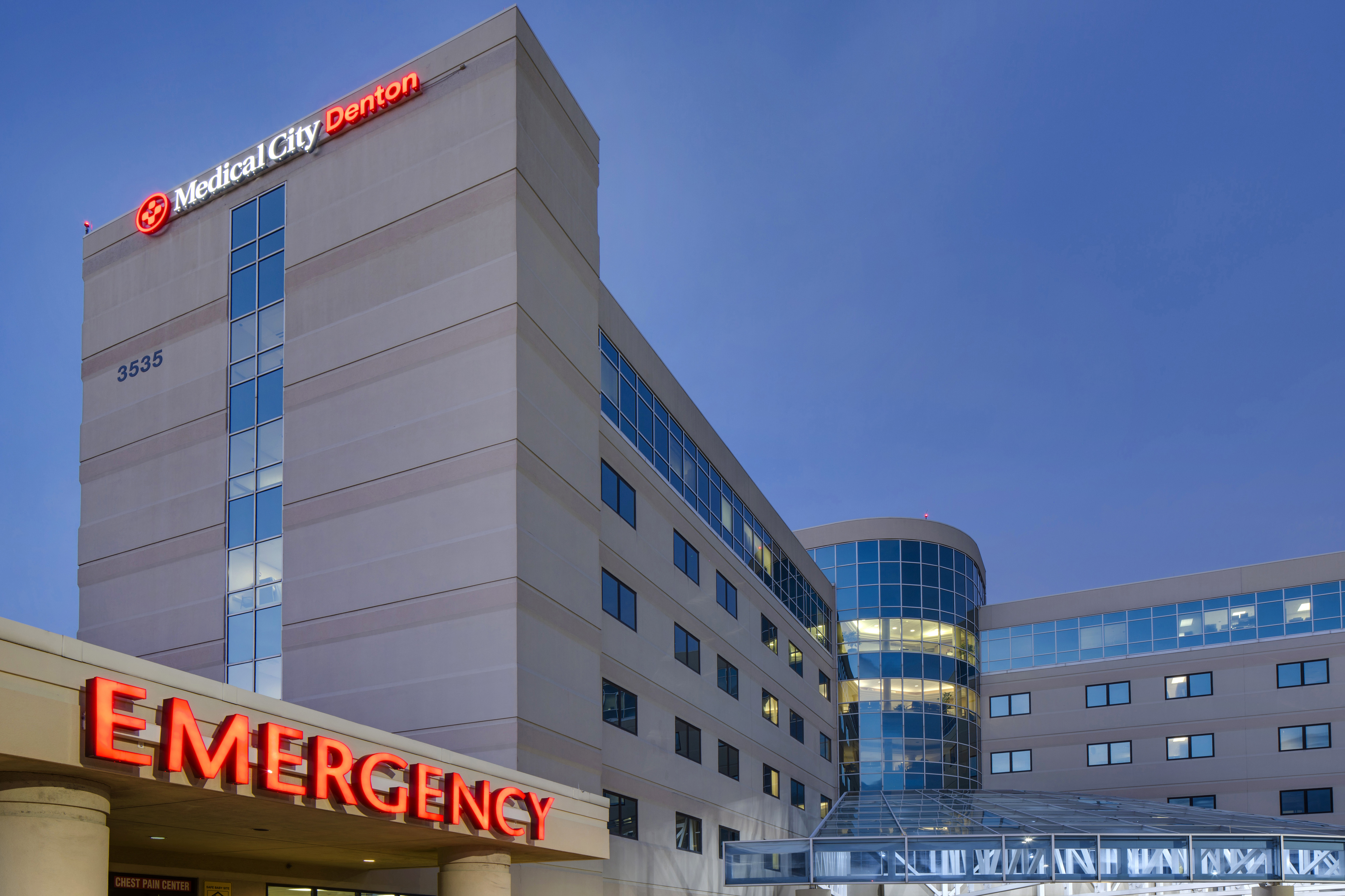 Exterior of Medical City Denton with Emergency signage lit in Red.