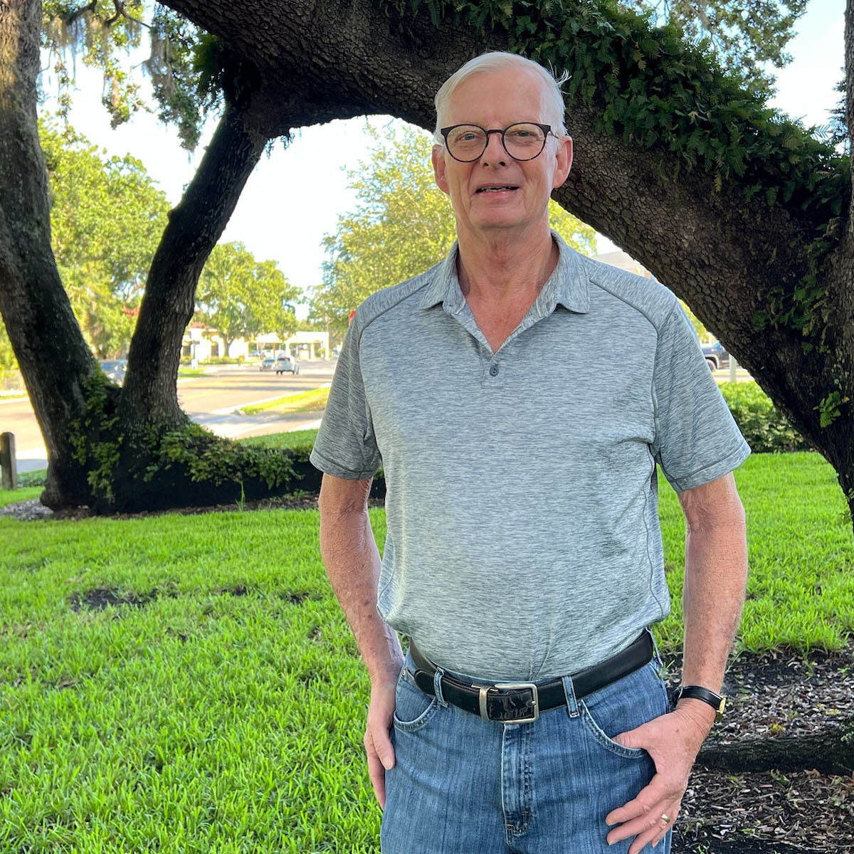 Ross Chinander standing in front of a tree