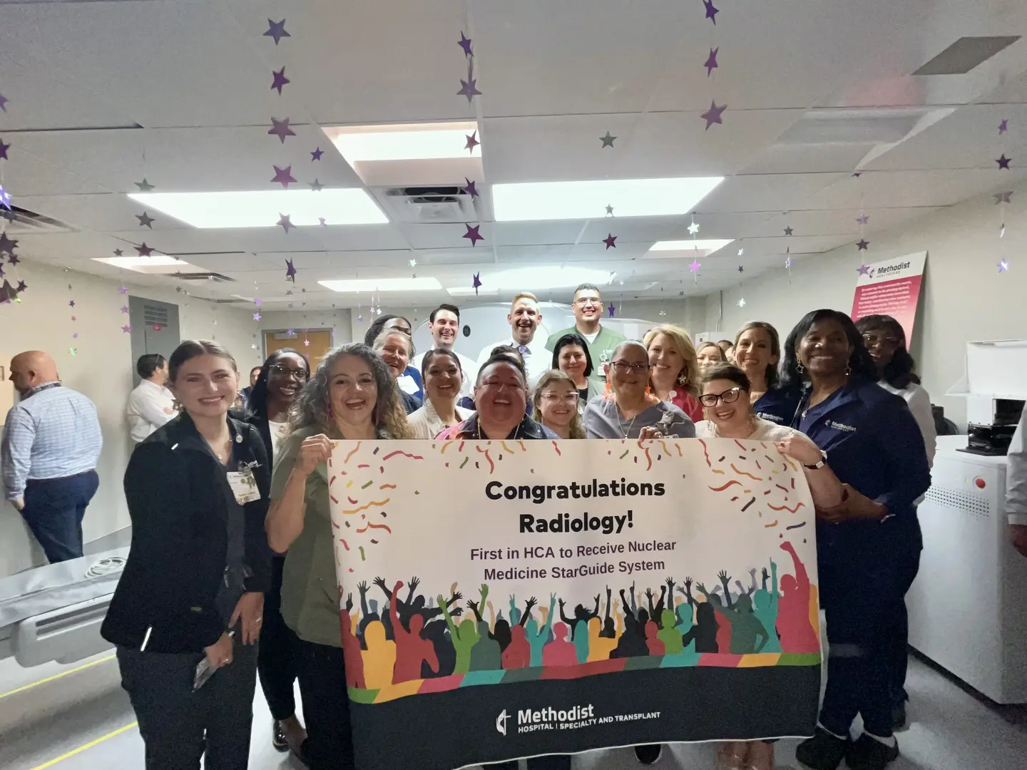 Staff pose with banner congratulating the radiology department.