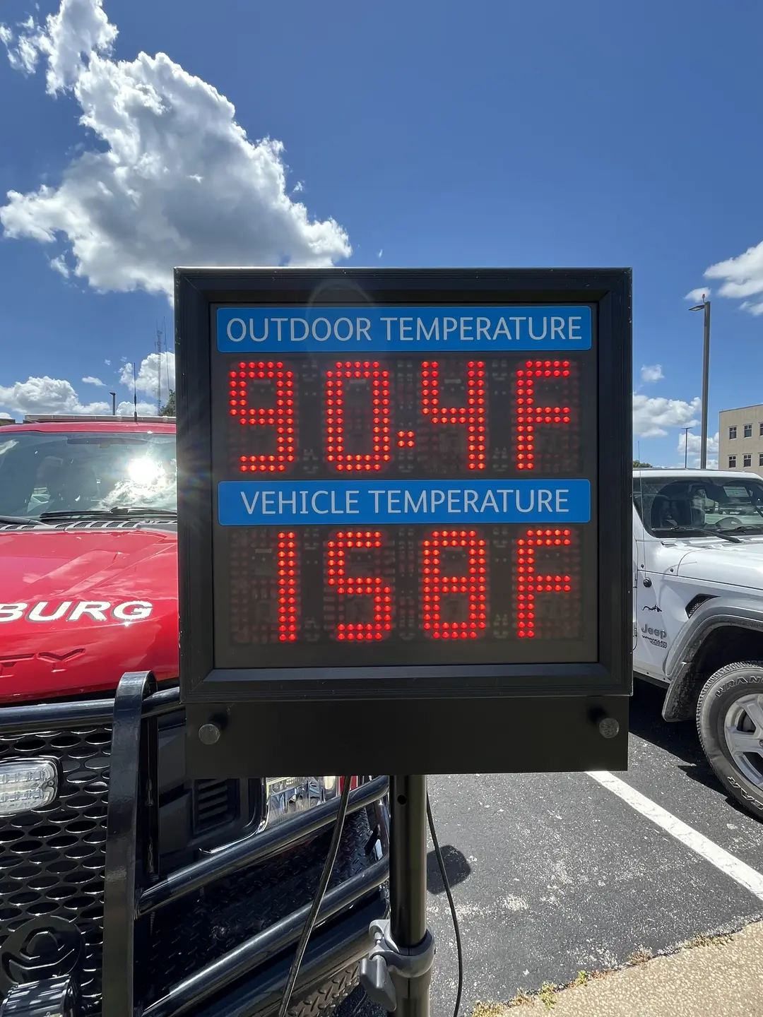 close-up of sign measuring temperature outside and inside a vehicle; "outdoor temperature: 90.4 degrees Fahrenheit" "indoor temperature: 158 degrees Fahrenheit"
