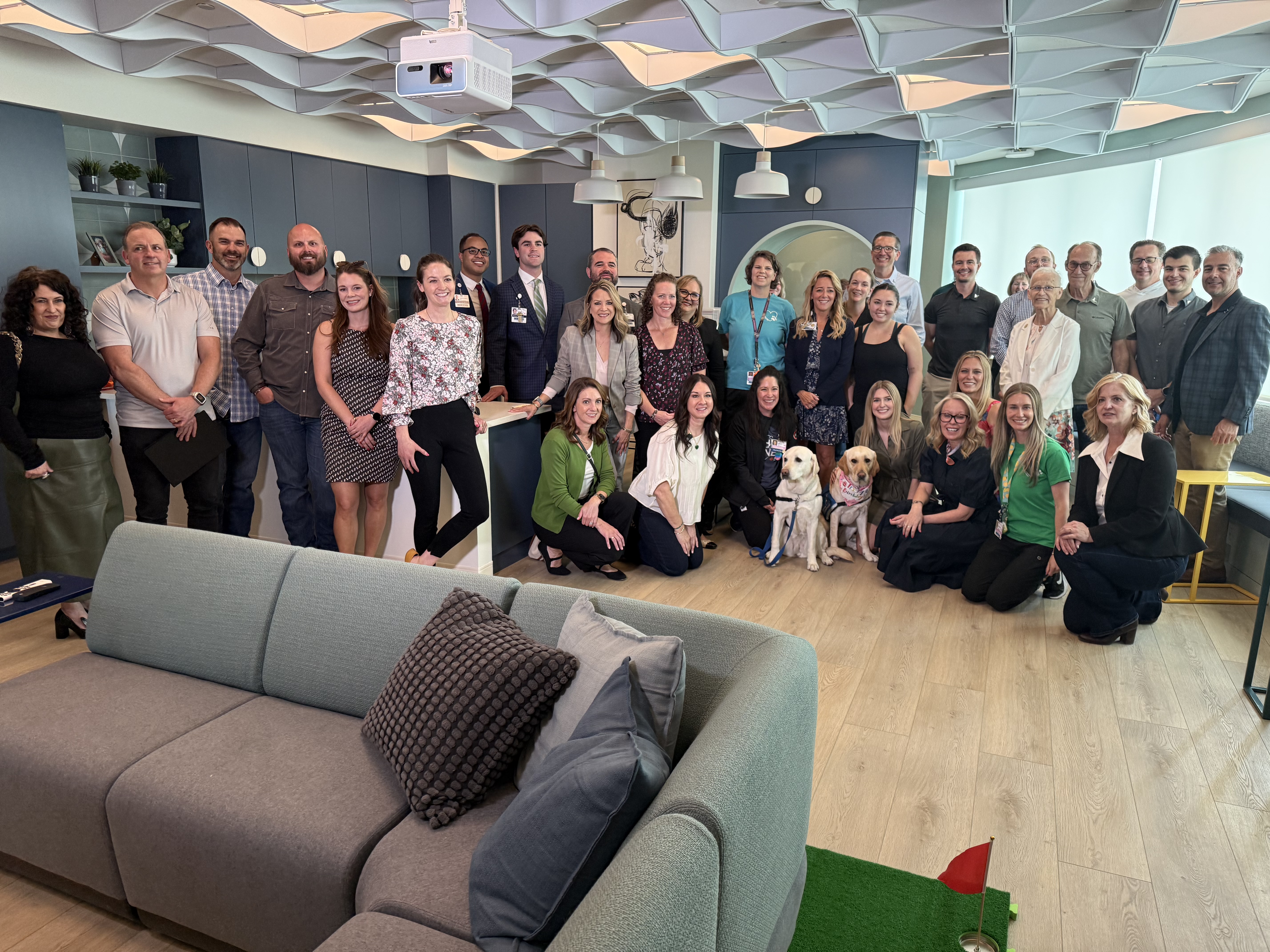 Colleagues and donors gather at the ribbon cutting for the new teen lounge.