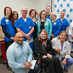 Britlynn is seated in a wheelchair, posing for a picture with Overland Park Regional Medical Center staff.