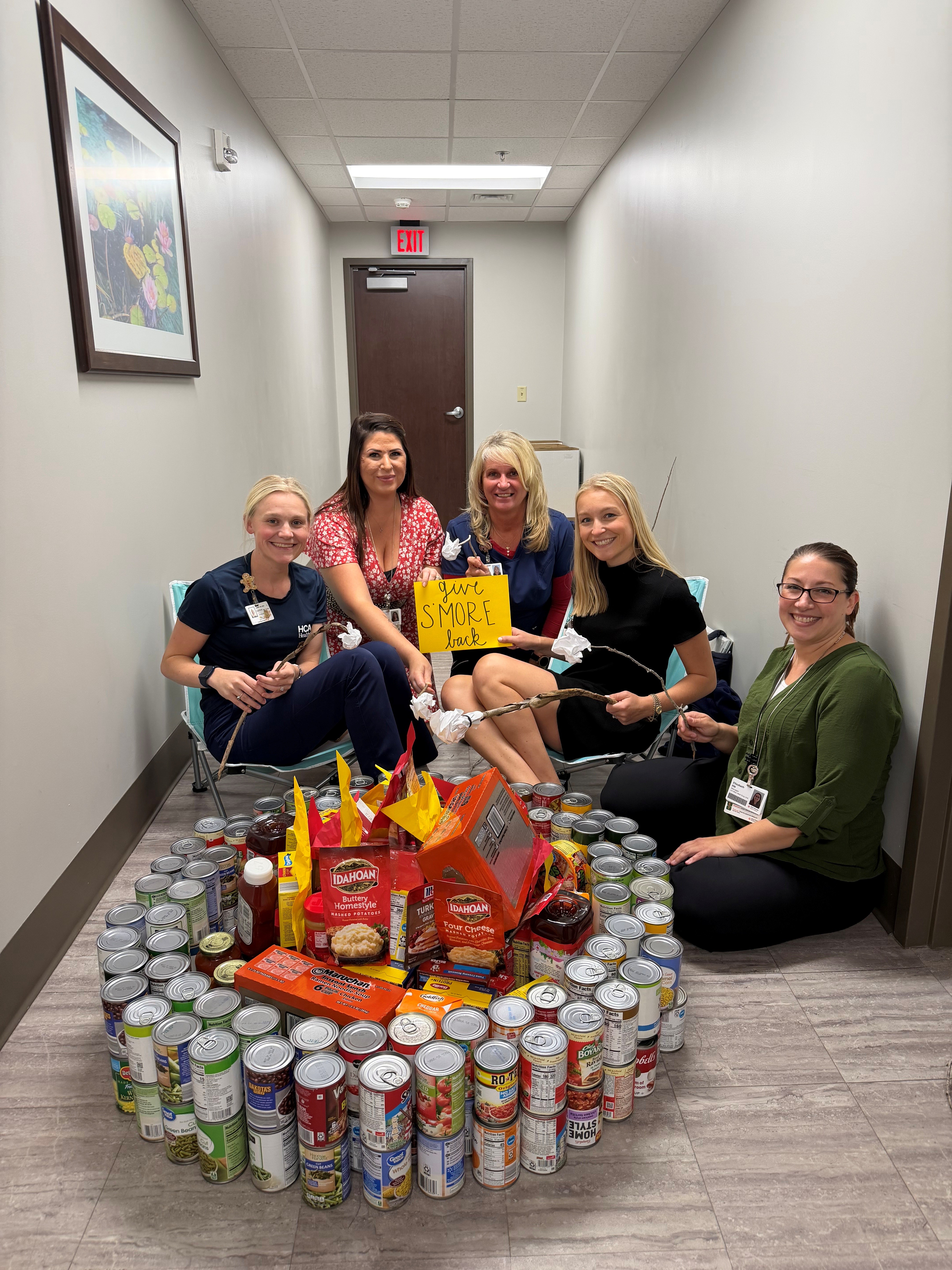 Nurse managers from HCA Florida Ocala Hospital pose with the “campfire” structure they built with donations from hospital colleagues to support families at College Park Elementary School in Ocala.