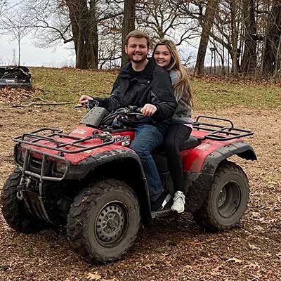 Carson Barnes and his girlfriend riding an atv.