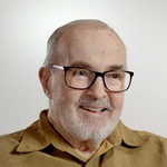 Robert Cuthbertson smiles while wearing a yellow button-up shirt.