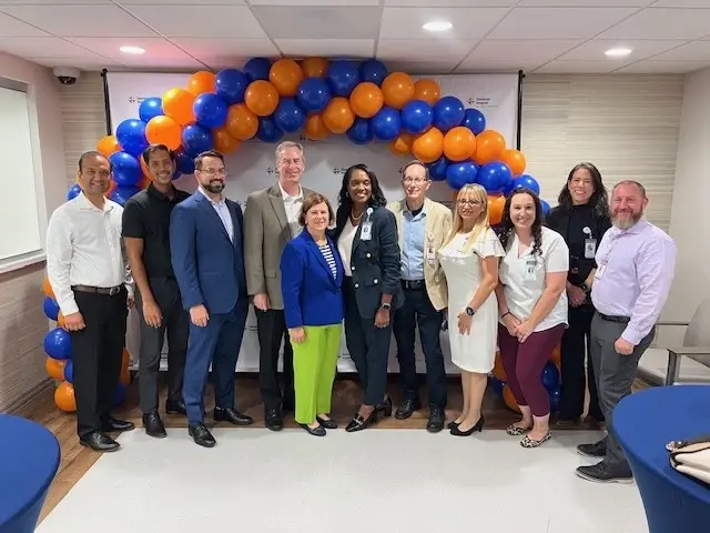 HCA Florida team members posing with ceremonial ribbon at grand opening.