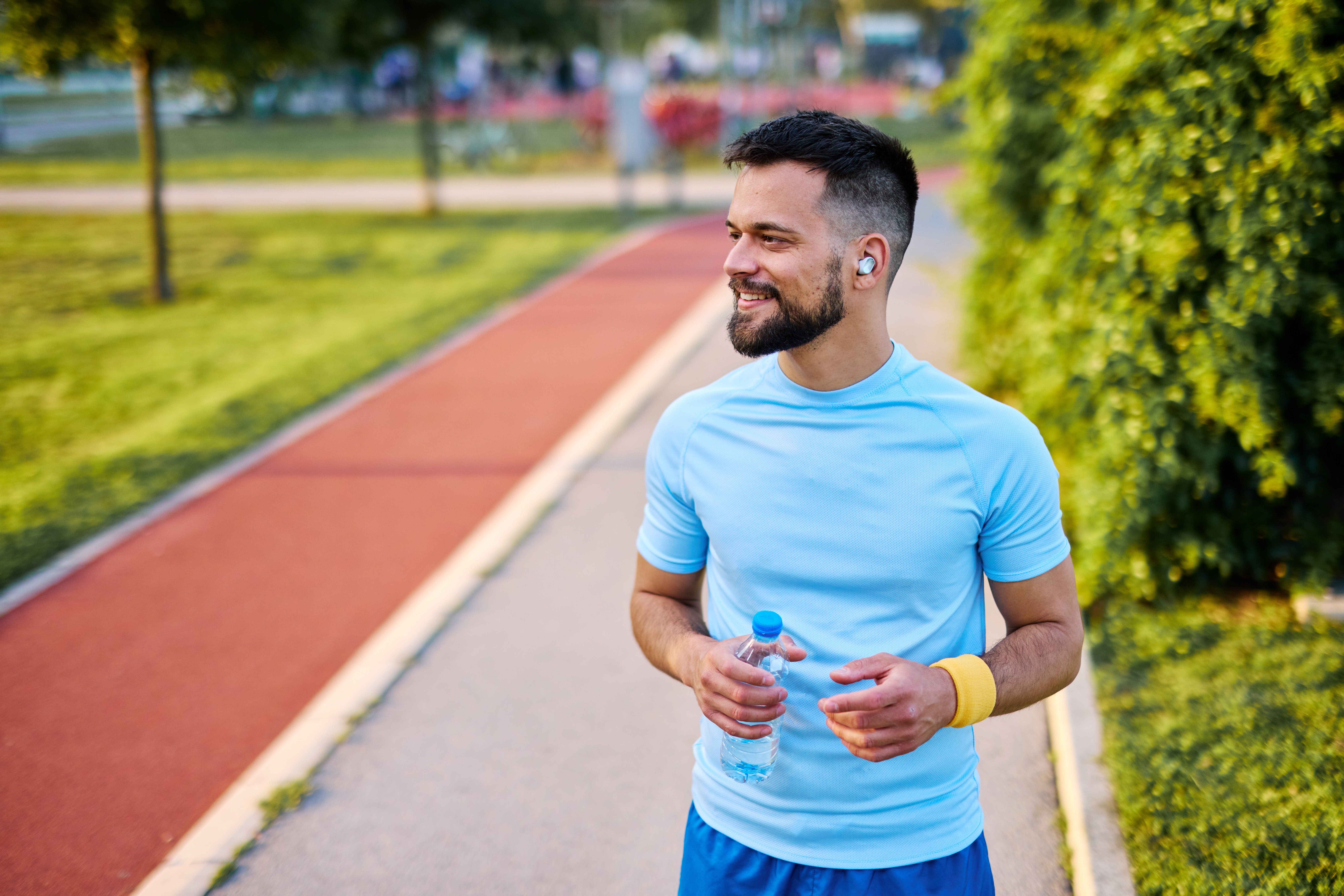 Man jogging and stretching his shoulder.