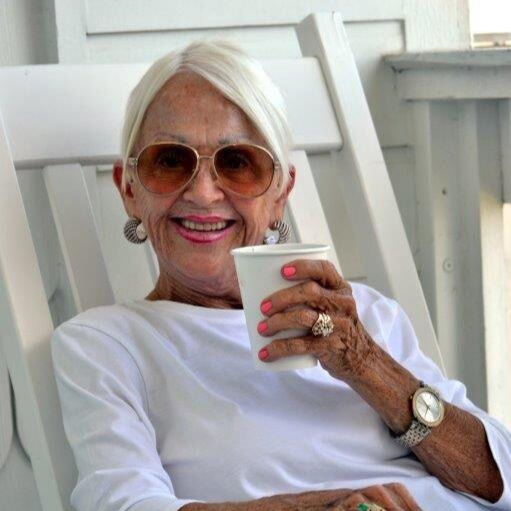 Annie Zimmerman relaxing on her patio, smiling with a cup of coffee.
