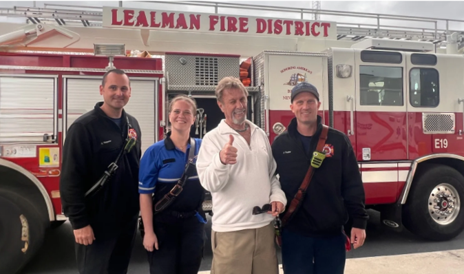 Eugene Noble and HCA staff posing in front of a firetruck.