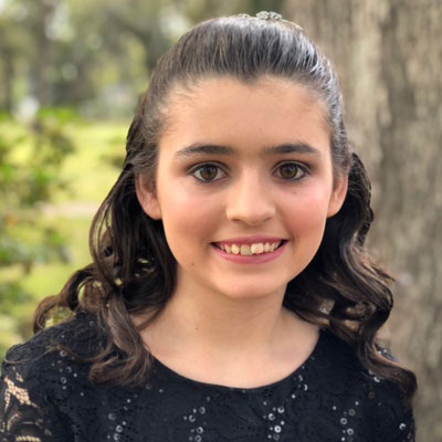 Kyia Agee smiles while wearing a black lace dress.