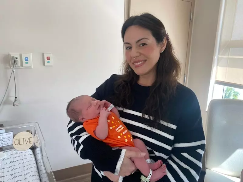 Yoiris Varela-Mora holds her baby girl, Olive, while posing for a photo in their hospital room.