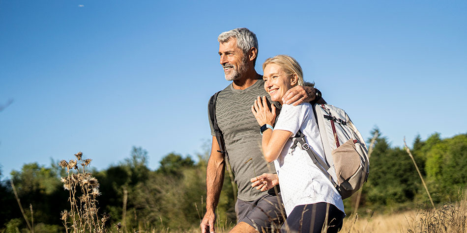 Senior man and woman embracing and walking outdoors