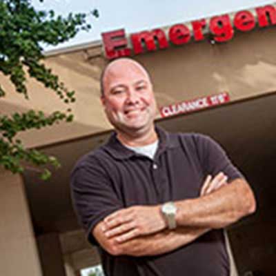Michael Willis smiling, stands with arms crossed, outside of the ER at Doctors Hospital of Augusta.