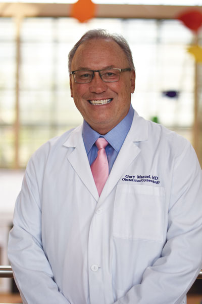 Dr. Gary P. Manuel, smiling.